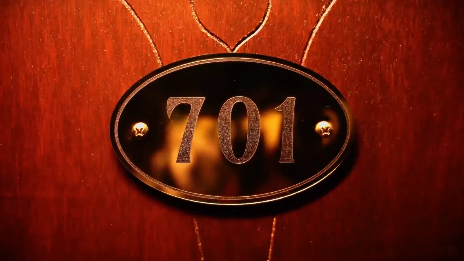 A brass number 701 on a timber suite door in Hotel: Murder Mystery